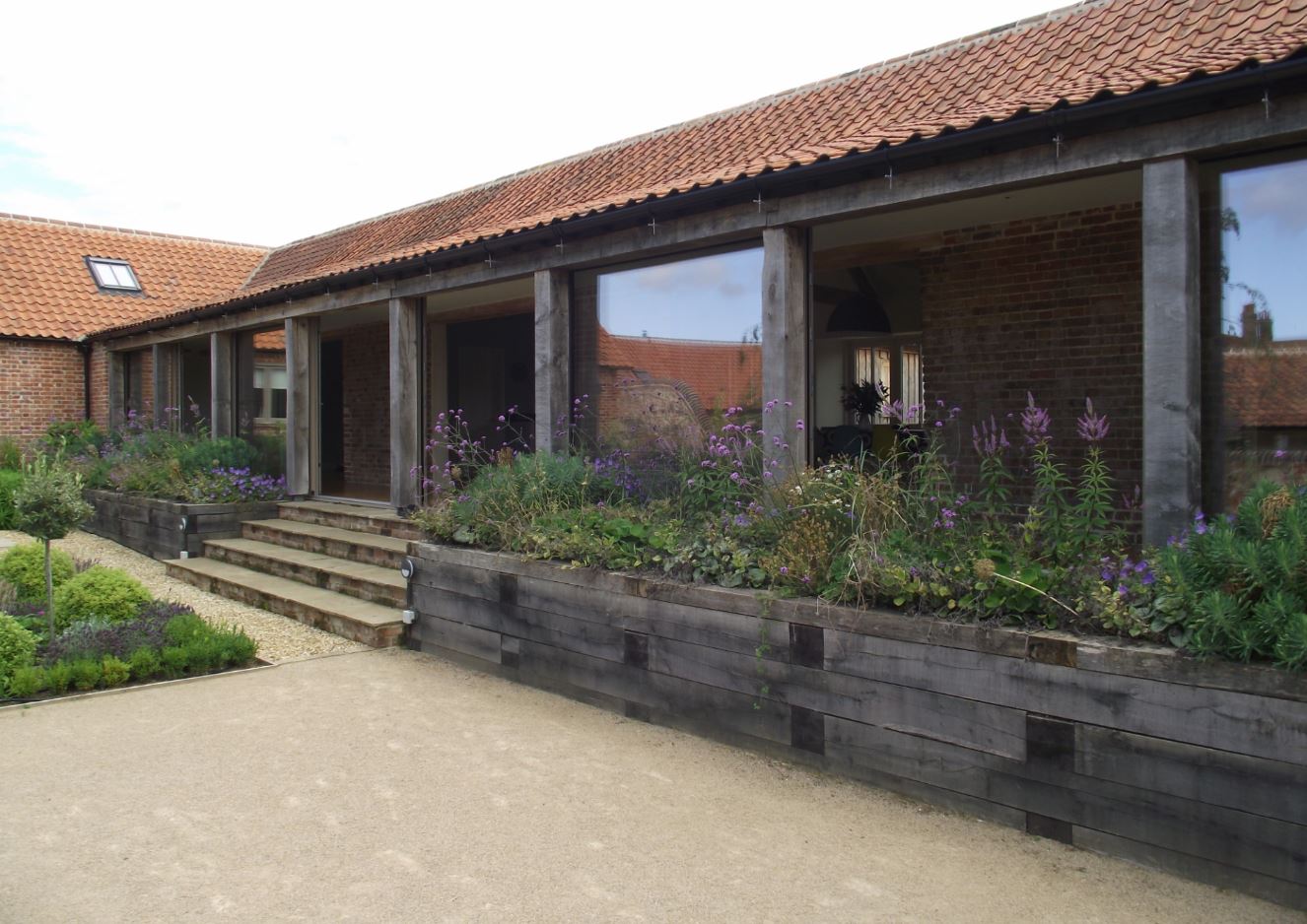 Sliding glazed openings set behind joinery details, planting complementing build form.