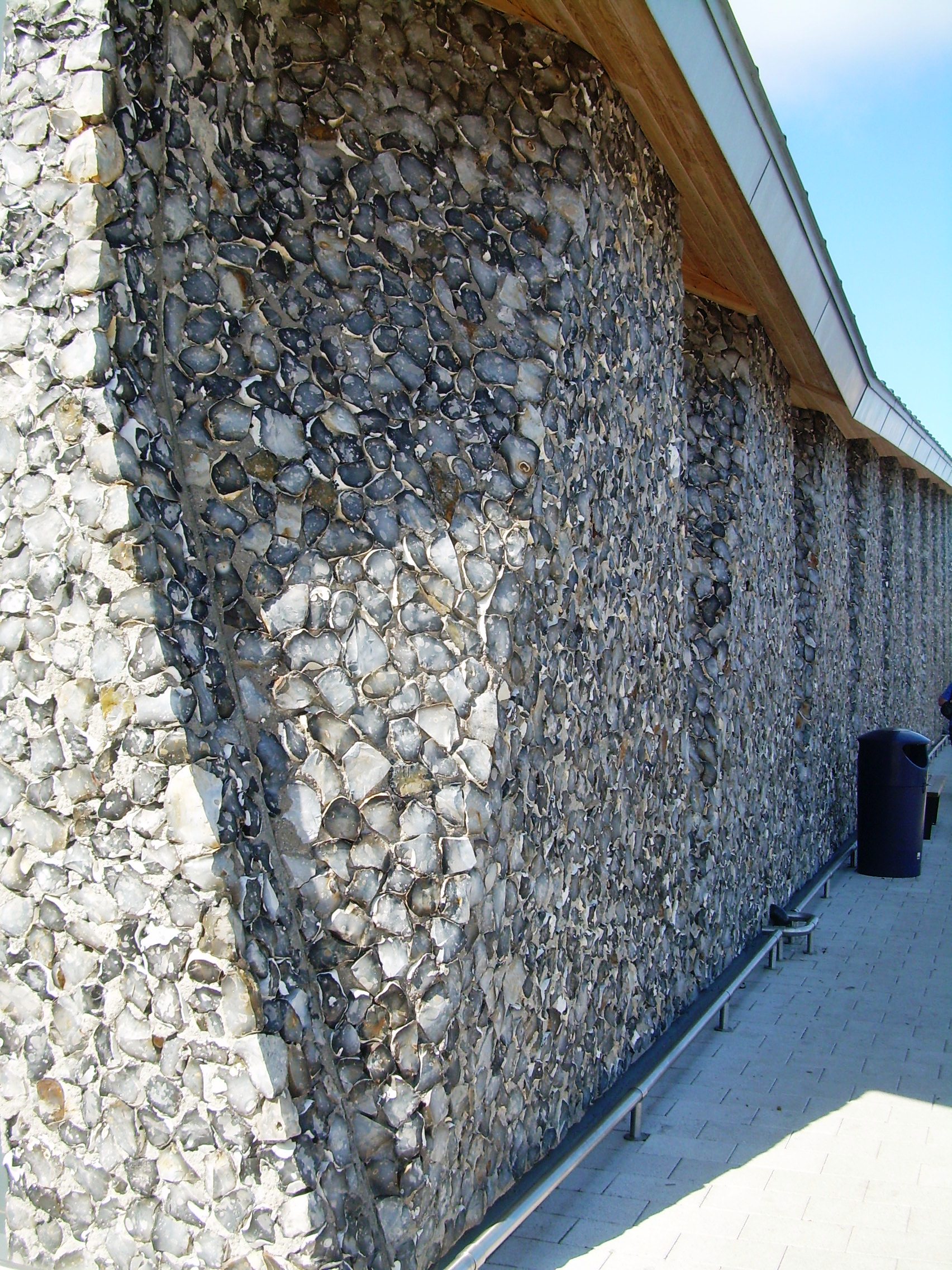 Knapped flintwork, oversailing eaves and undulating elevation provides an interesting design solution.